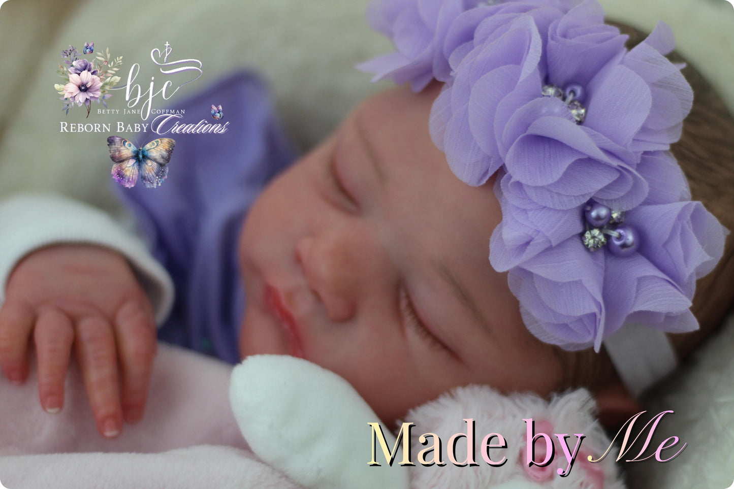 A newborn baby girl wearing a purple flower headband and sleeping peacefully, with the text "Made by Me" and "BJC REBORN BABY CREATIONS" displayed in the image.