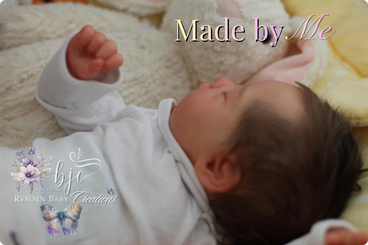 A newborn baby is peacefully sleeping, with the text "Made by Me" displayed above the baby.
